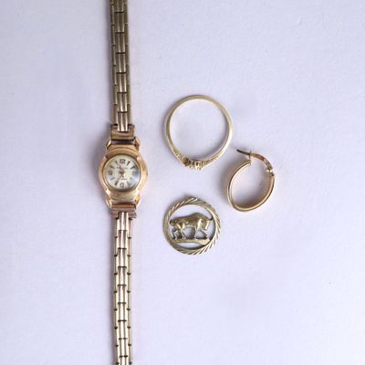 a watch, ring, and other jewelry on a white surface
