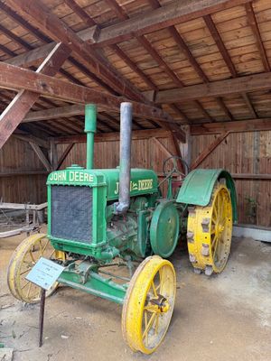 un tracteur vert qui se trouve dans une grange