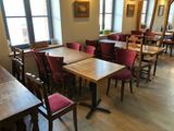 many tables and chairs in this restaurant with a view of the city