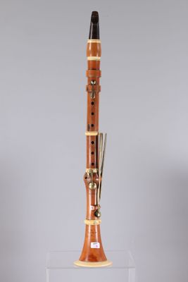 a close up of a wooden clarinet on a clear stand