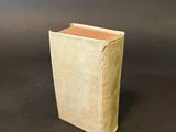 an old book sitting on top of a table next to a black background