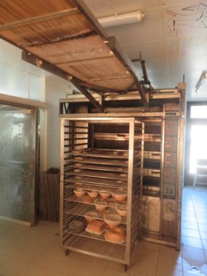 de nombreux plateaux de pain posés sur une étagère dans une cuisine