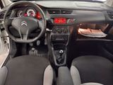 the interior of a small car with a steering wheel and dashboard controls
