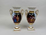 two vases with pictures of people on them sitting on a table