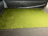 a green area rug on the floor in a living room