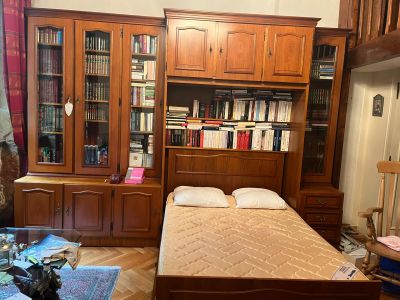 un lit avec un matelas dans une chambre équipée de bibliothèques