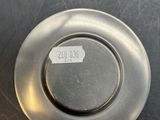 a silver plate with a sticker on it on a table