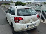 a dirty white car parked on the side of the road