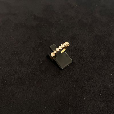a close up of a black and gold ring on a black surface