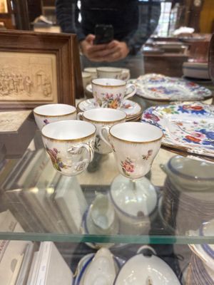 many cups and saucers sitting on a glass table