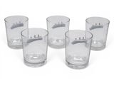 four shot glasses are lined up on a white surface