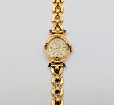 une image d'un gros plan d'une montre-bracelet sur une surface blanche