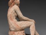an image of a sculpture of a woman sitting on a rock