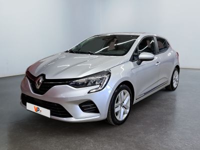 Une voiture argentée est garée dans une pièce aux murs blancs