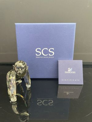 une figurine en verre représentant un homme tenant une cigarette devant une boîte bleue