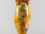 yellow vase with pink flowers on it on a white background