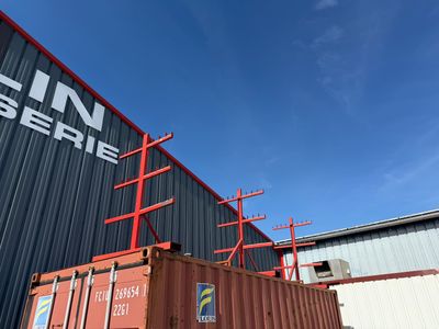 un conteneur d'expédition rouge posé devant un immeuble