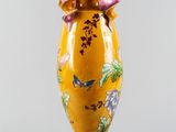 a yellow vase with a pink bow on top of it