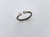 a silver ring with two pearls on it
