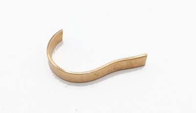 gros plan d'une bague en or sur une surface blanche