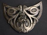 an image of a silver broochle with a crown on it