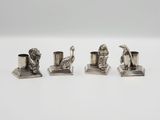 trois figurines en argent représentant des animaux et un oiseau, posées sur un socle