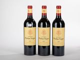 trois bouteilles de vin rouge posées côte à côte sur une table
