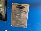 a close up of a blue machine with a metal plate on it