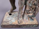 a statue of a man holding a dog on a base