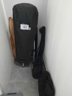 un sac de voyage posé à côté d'une valise sur le sol
