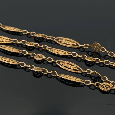 a close up of three gold chains on a black surface