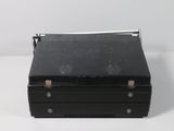 a black box with a metal handle on a white surface