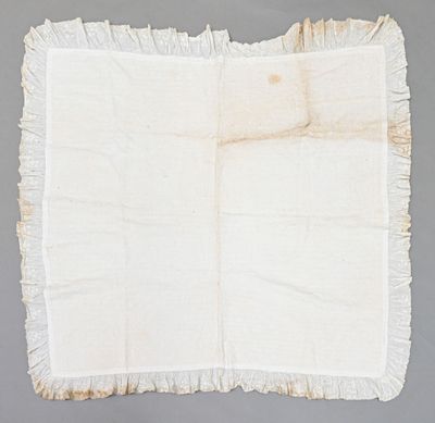 un vieux morceau de tissu aux bords effilochés sur un fond gris