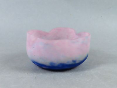 un bol rose et bleu posé sur une surface blanche