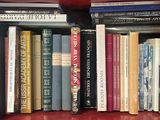 de nombreux livres qui se trouvent tous ensemble sur une étagère rouge