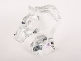 tête de cheval en verre transparent posée sur un socle transparent, sur fond blanc