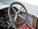 steering wheel of an old car with a red seat and a black seat
