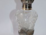 a glass vase with a silver lid on a white background