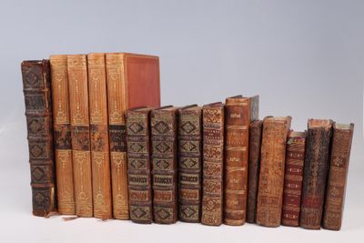 several old books stacked on top of each other on a white surface