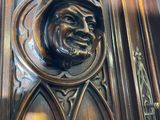 a close up of a carved wood door with a face on it