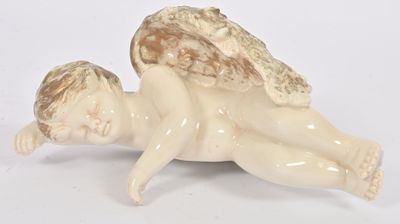 Sujet en faïence à décor d'angelot émaillé crème et dore, (p…