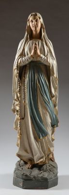 La statue de la Vierge Marie tient un chapelet dans ses mains.
