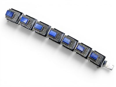 un gros plan d'un bracelet orné de pierres bleues sur un fond blanc