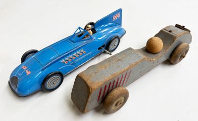 deux voitures jouets assises l'une à côté de l'autre sur une surface blanche
