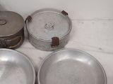 four pans sitting on a marble counter top next to each other