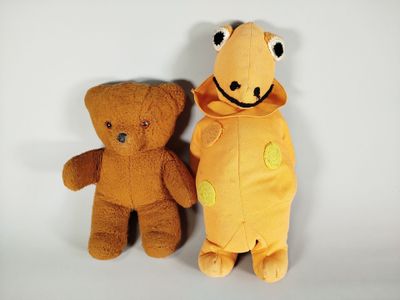 deux peluches assises l'une à côté de l'autre sur une surface blanche