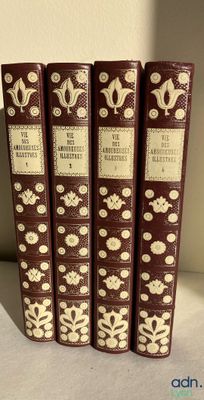 four books are lined up on a shelf in a row