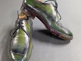 pair of men ' s shoes with green and purple paint on them
