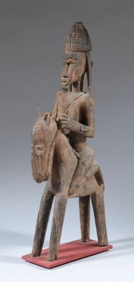 an old wooden statue of a man riding a horse with a helmet on