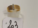 gros plan d'une bague en or surmontée d'un diamant